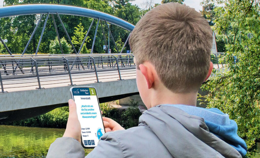 Dieses Foto zeigt einen Jungen, der eine Entdeckertour des SAL mit der App auf seinem Smartphone macht.