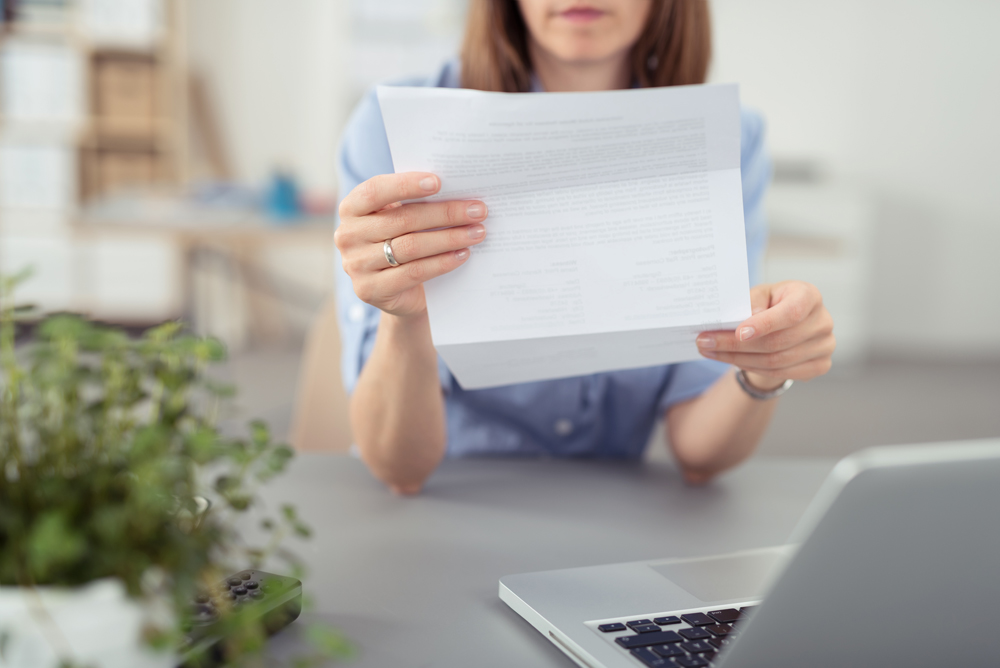 Frau am Schreibtisch mit Brief in der Hand | SAL